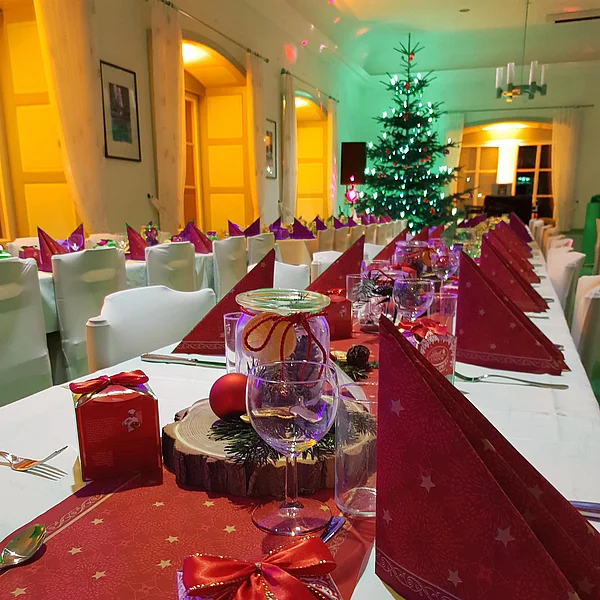 Festlich gedeckte Tische im Kaisersaal, im Hintergrund ein geschmückter Weihnachtsbaum