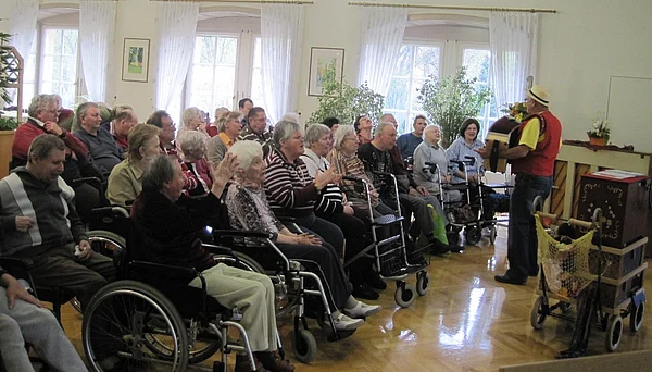 Kaisersaal des Schloss Meerholz mit vielen Bewohnern, teilweise singend und klatschend, davor ein Musikant mit Akkordeon