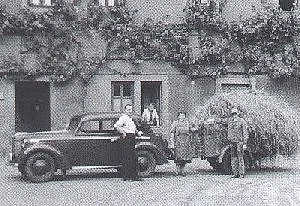 Historische Fotoaufnahme des Pflegeheim Meerholz, davor der Heimleiter an seinem Wagen