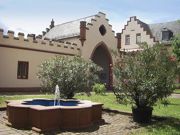 Begrünter Innenhof des Schloss Meerholz, mit einem Brunnen
